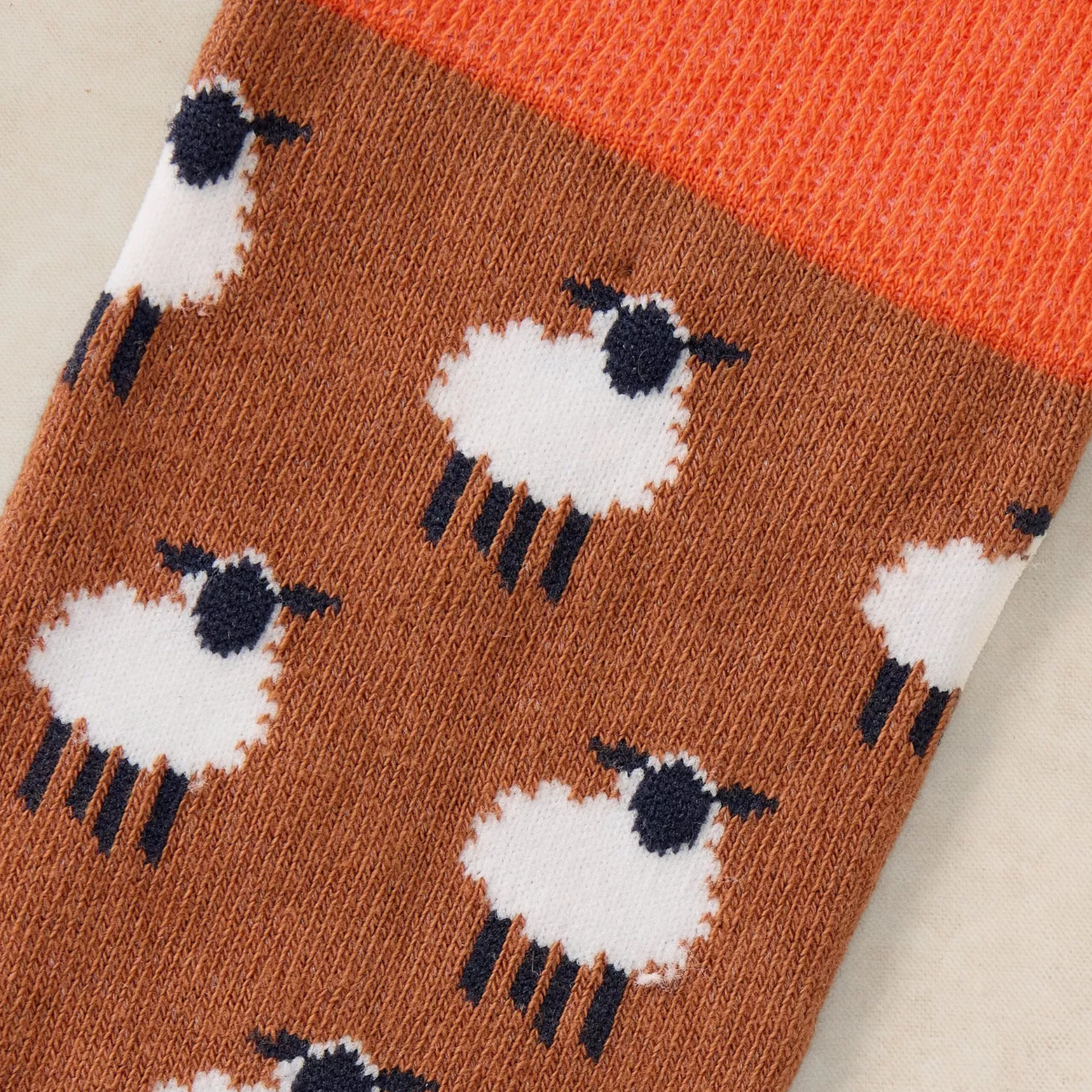Sock with sheep pattern on a brown background