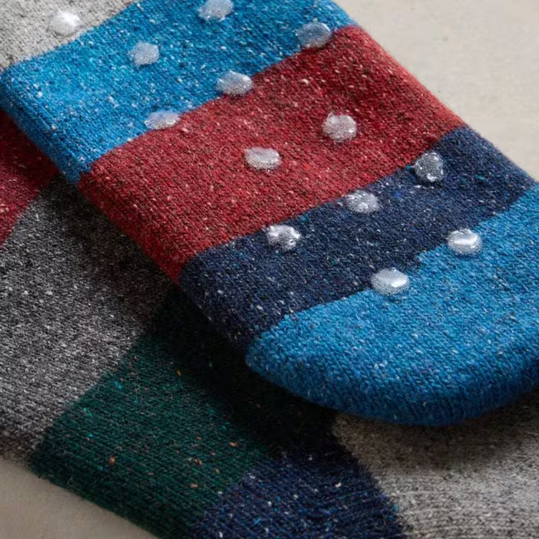 Multi-colored striped socks with textured knit and small, clear silicone grips on the soles.