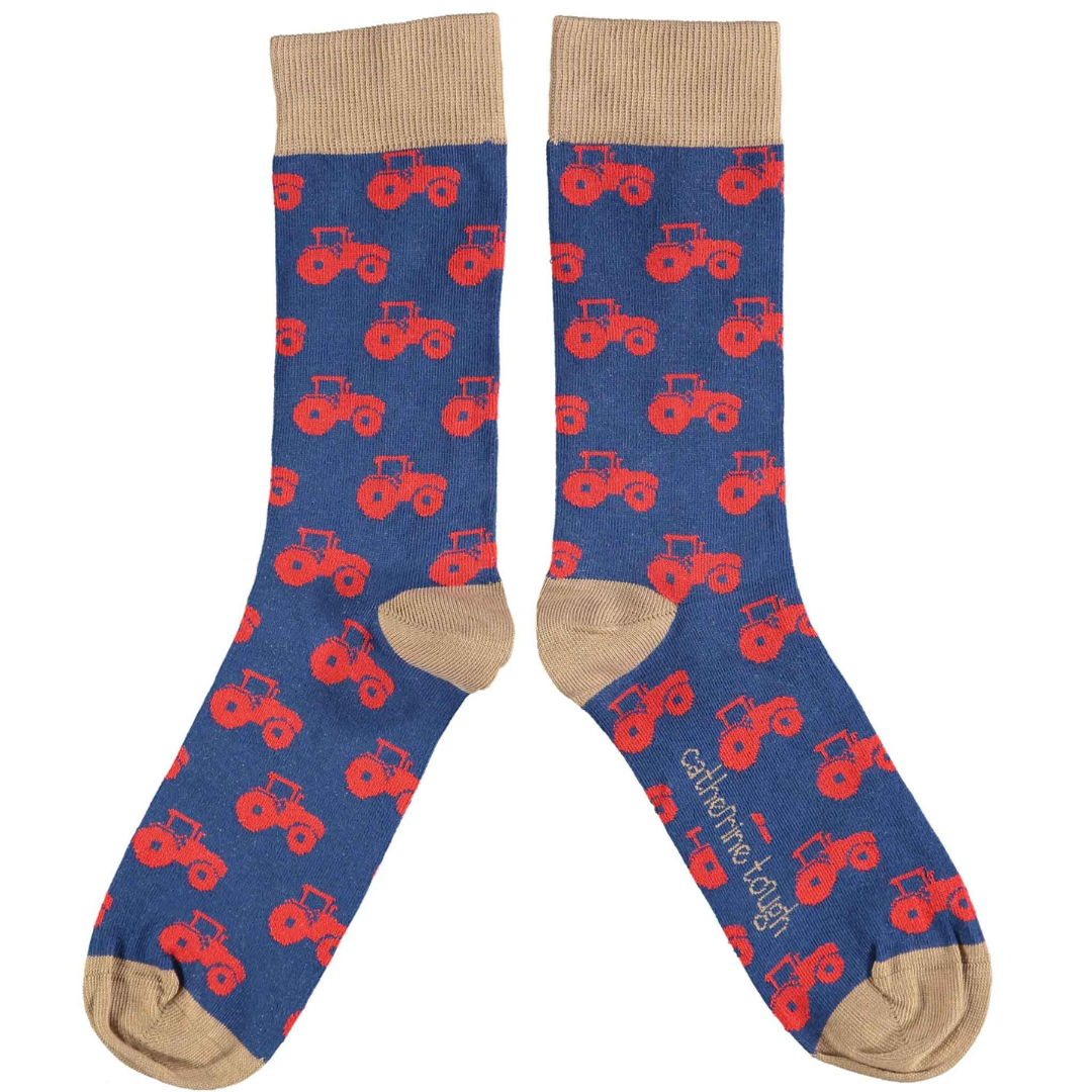 Pair of navy blue socks with a repeating pattern of red tractors.  Tan colored cuffs.