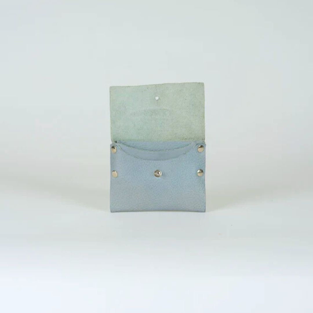 Light blue leather wallet open, showing interior.  Small, with silver studs and a single button closure.