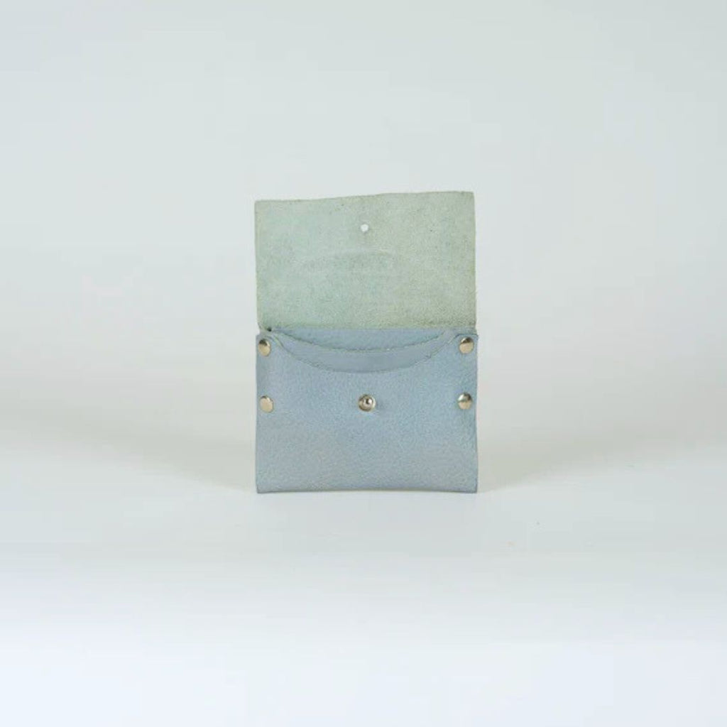 Light blue leather wallet open, showing interior.  Small, with silver studs and a single button closure.