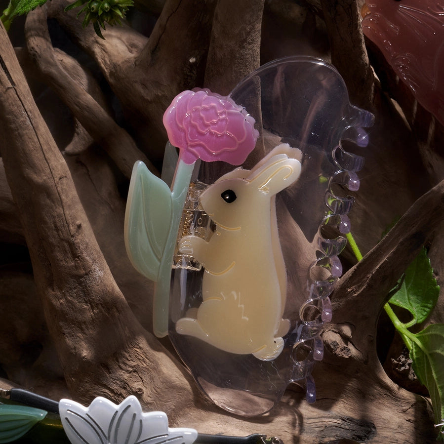 Decorative hair clip with a rabbit and flower design on a natural background