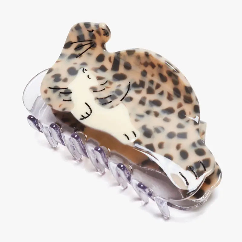 A hair clip in the shape of a seal holding a seal pup sits on a white background