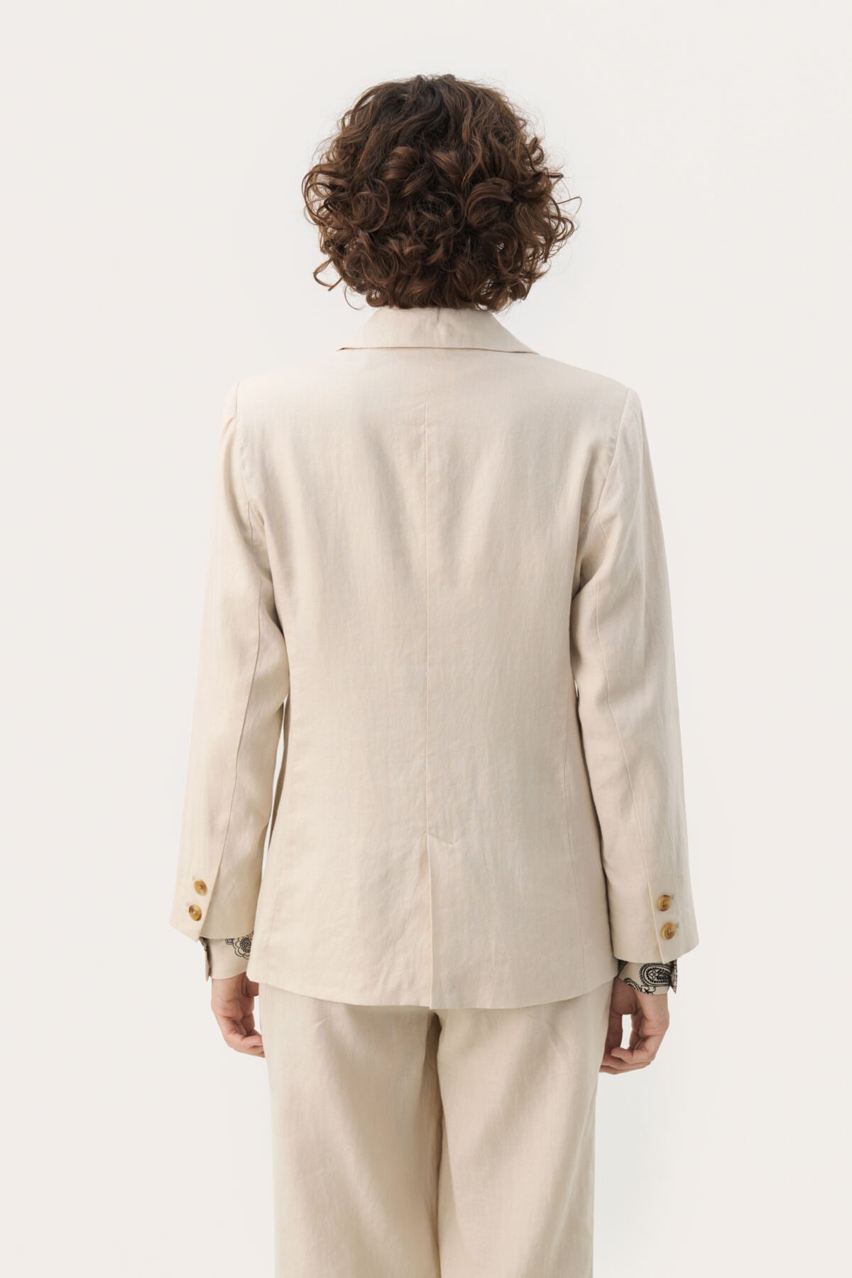 Person wearing a beige suit on a white background