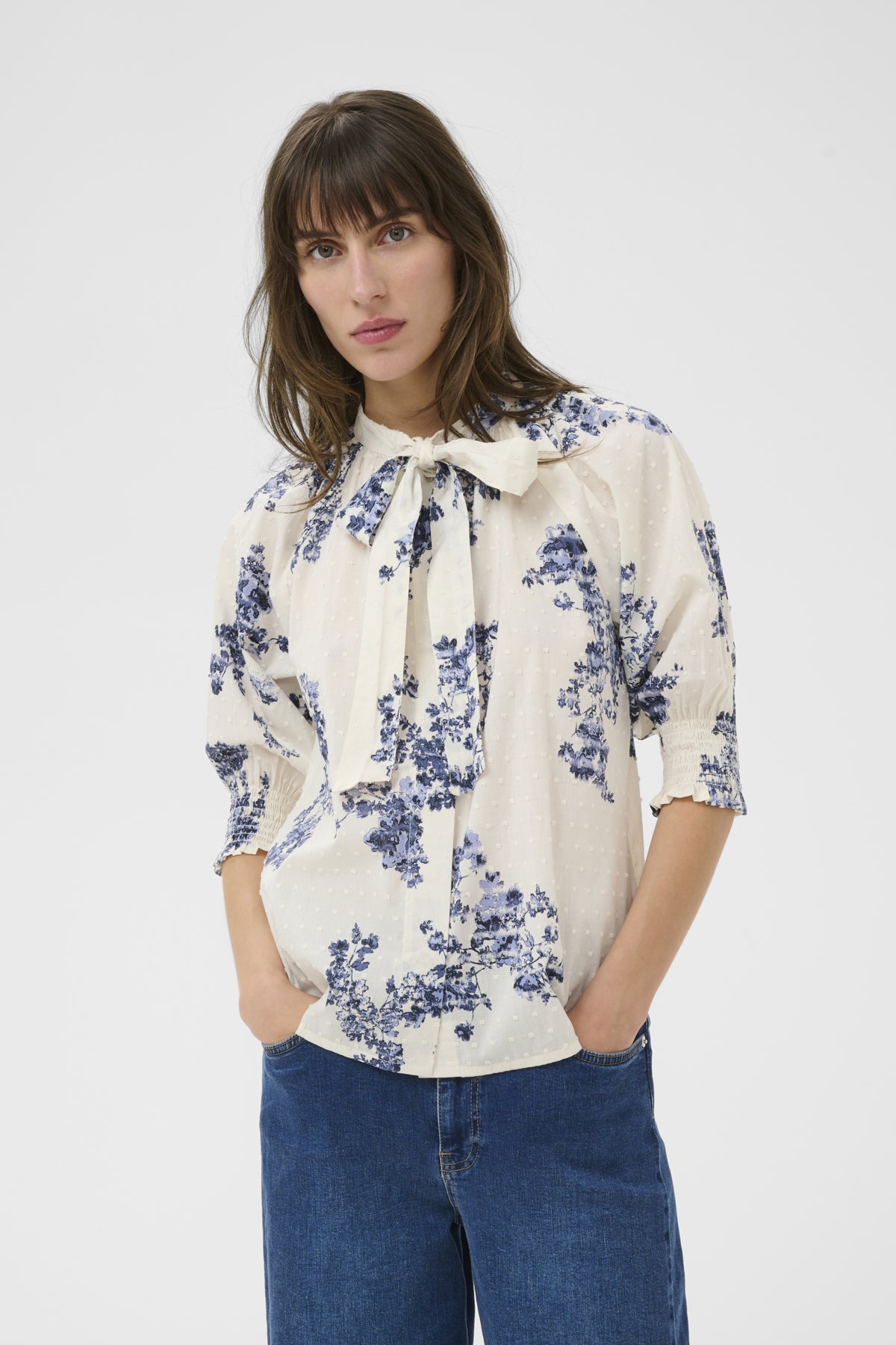 Woman wearing a floral blouse with a white background