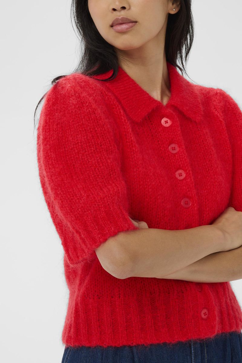 Person wearing a red knitted cardigan on a white background
