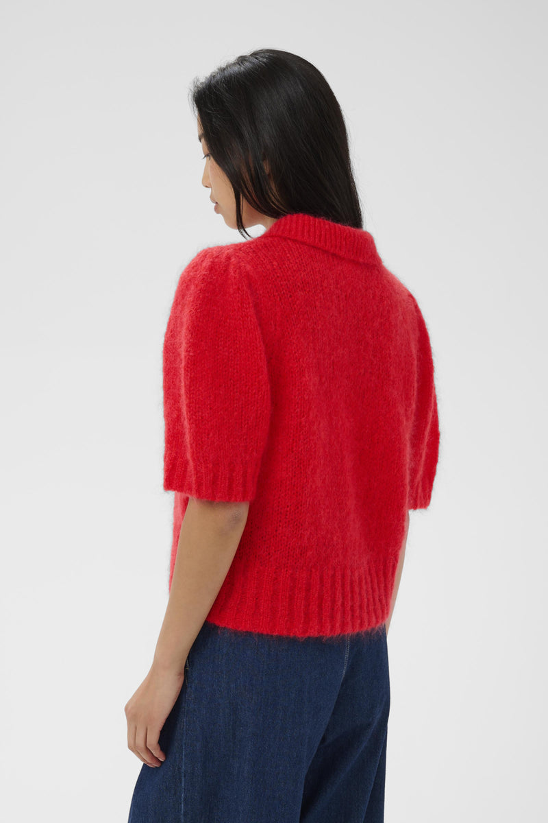 Person wearing a red sweater with short sleeves on a white background
