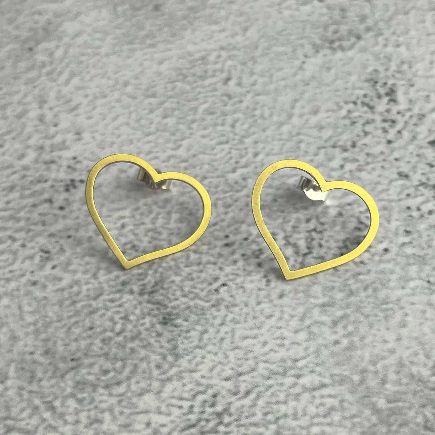 Pair of gold heart-shaped stud earrings with a thin outline.