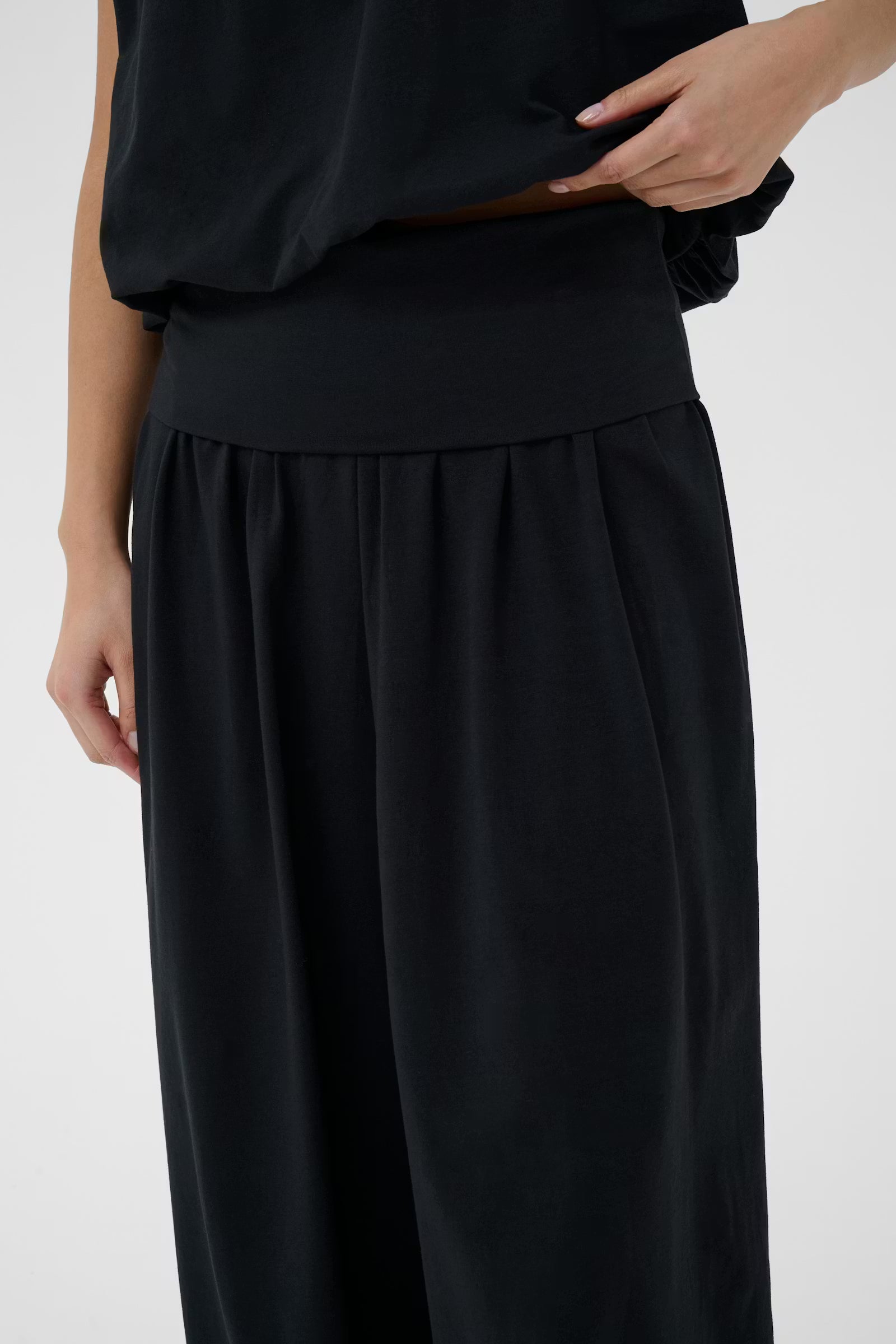 Person wearing a black outfit on a white background