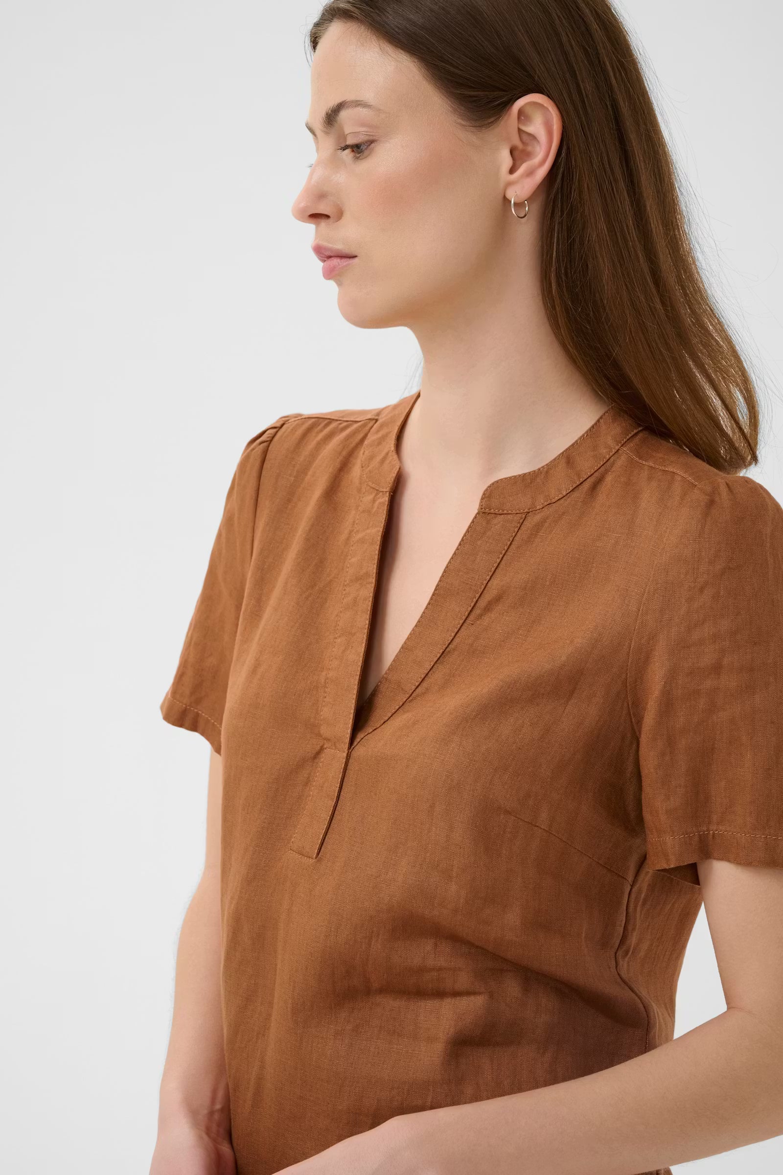 Woman wearing a brown shirt against a white background