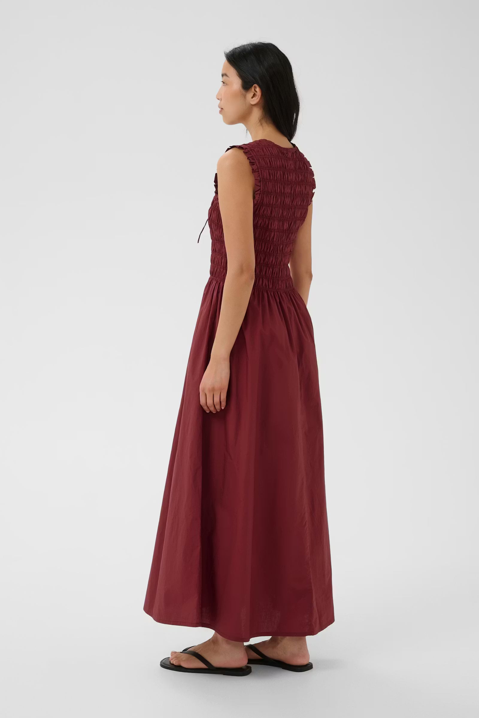Woman wearing a burgundy dress on a white background