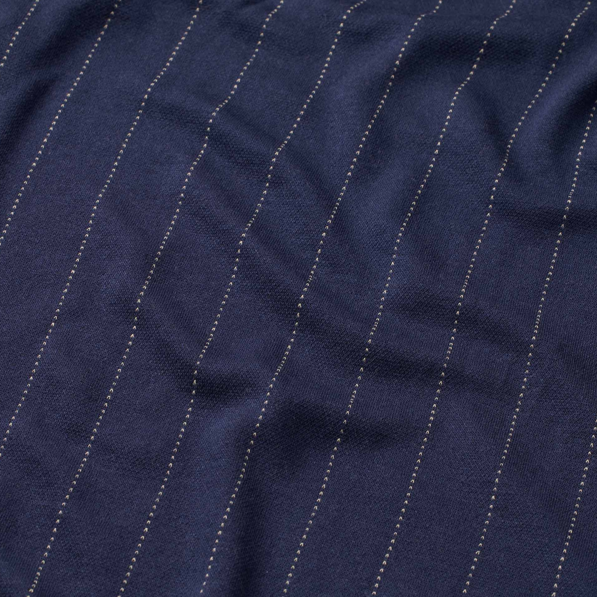 Close-up of navy blue fabric with white pinstripes