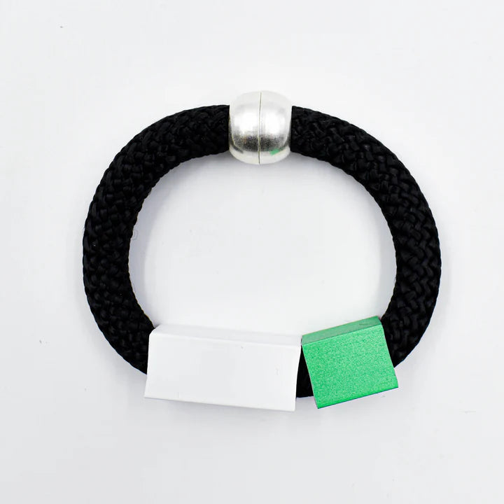 Black rope bracelet with silver bead accent and attached white and green labels.