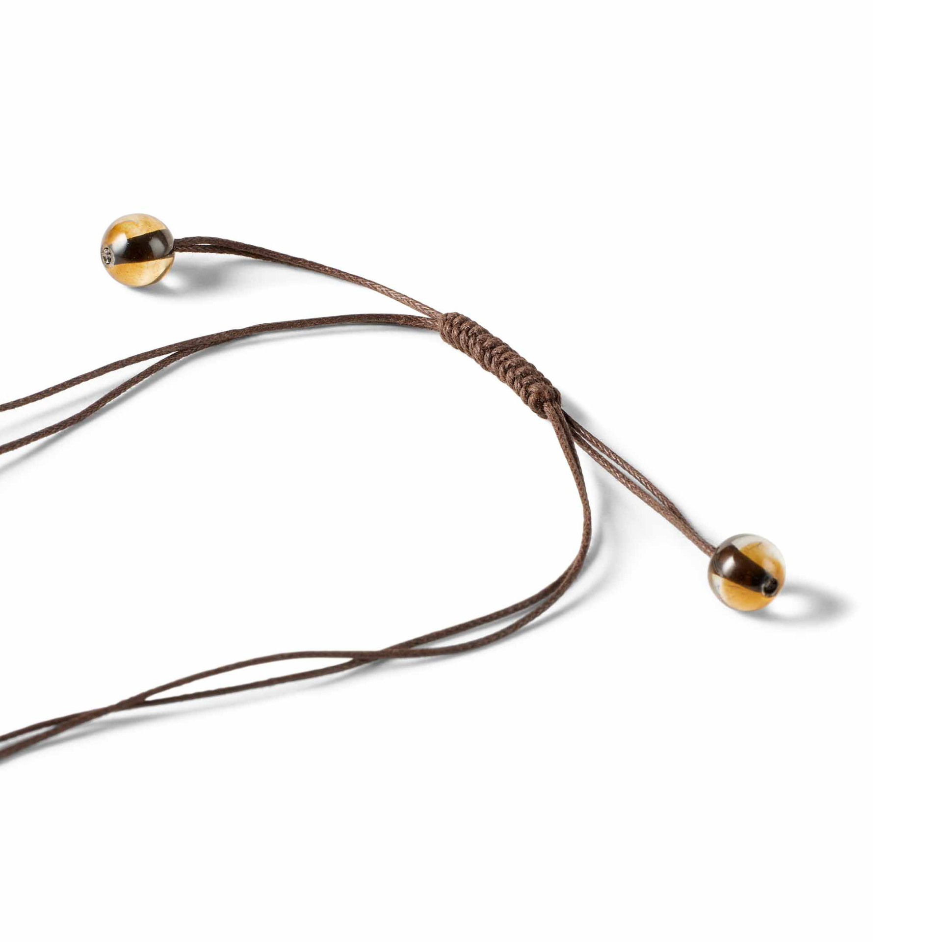 Brown cord with gold and clear coloured beads on a white background