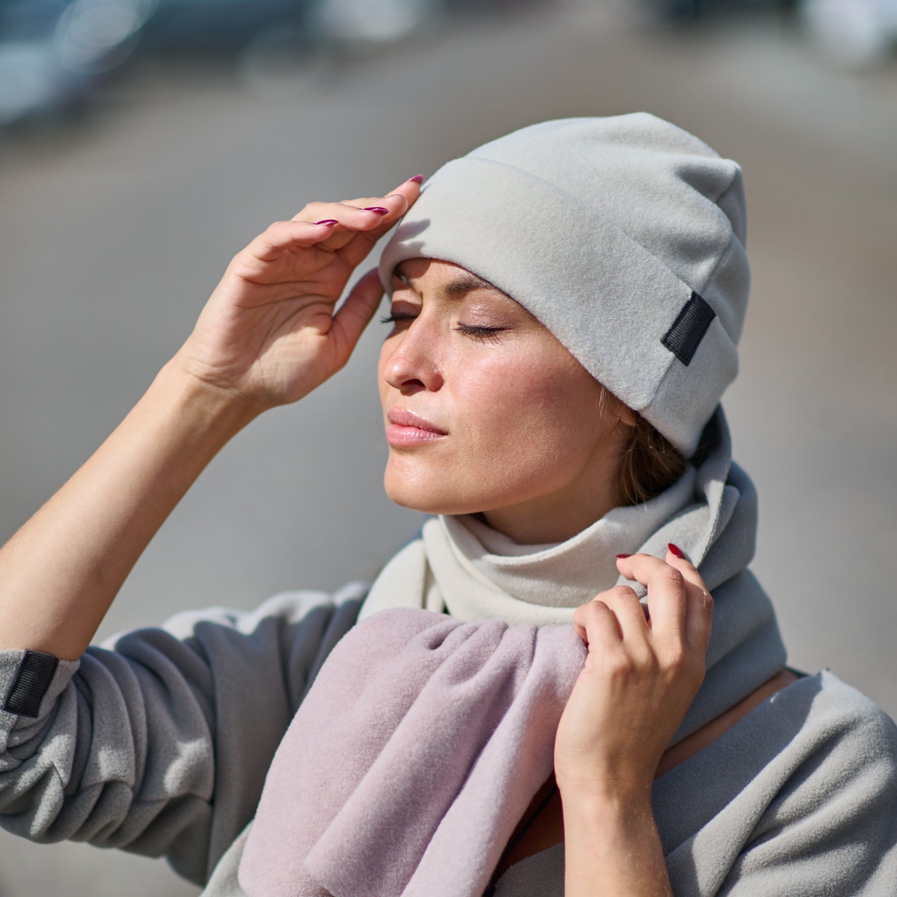Woman wearing a gray beanie and scarf outdoors