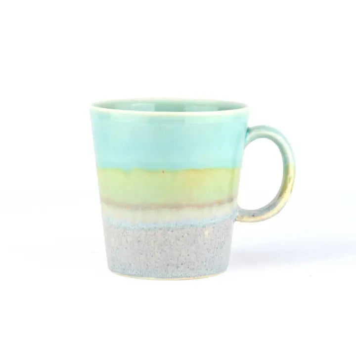 A light blue, green, and gray speckled ceramic mug with a handle.