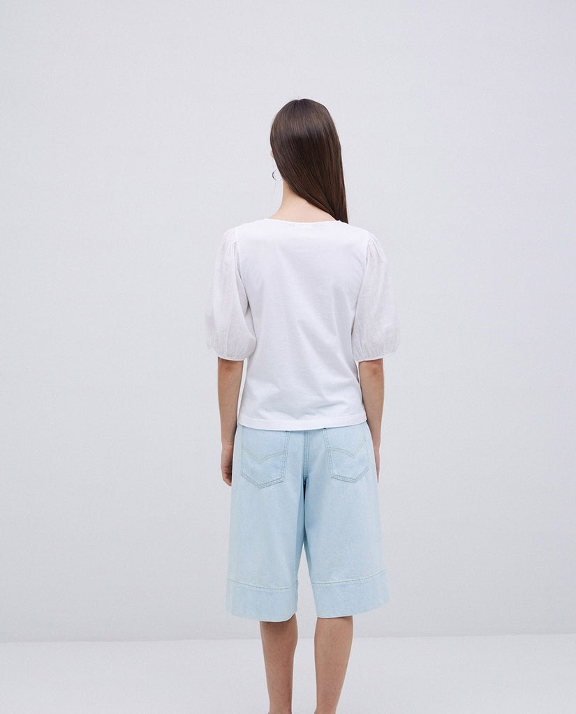 White puff-sleeve blouse and light blue denim culottes.