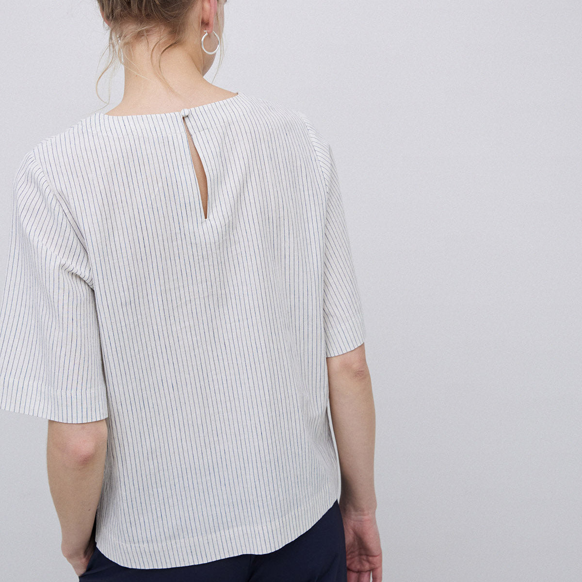 Off-white short-sleeve top with thin blue vertical stripes, keyhole back detail.