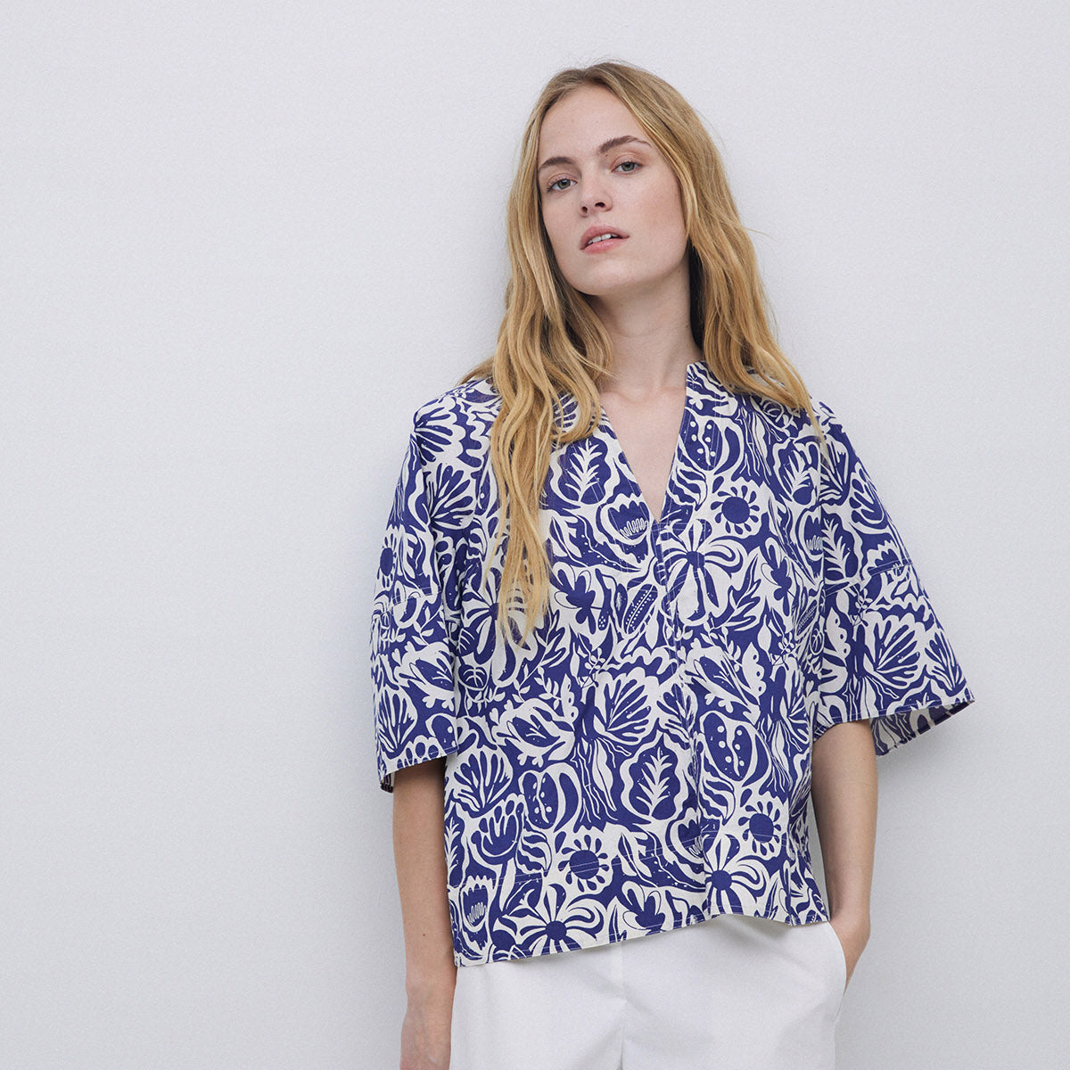Woman's short-sleeved blouse with a V-neck and a navy blue and white floral print.