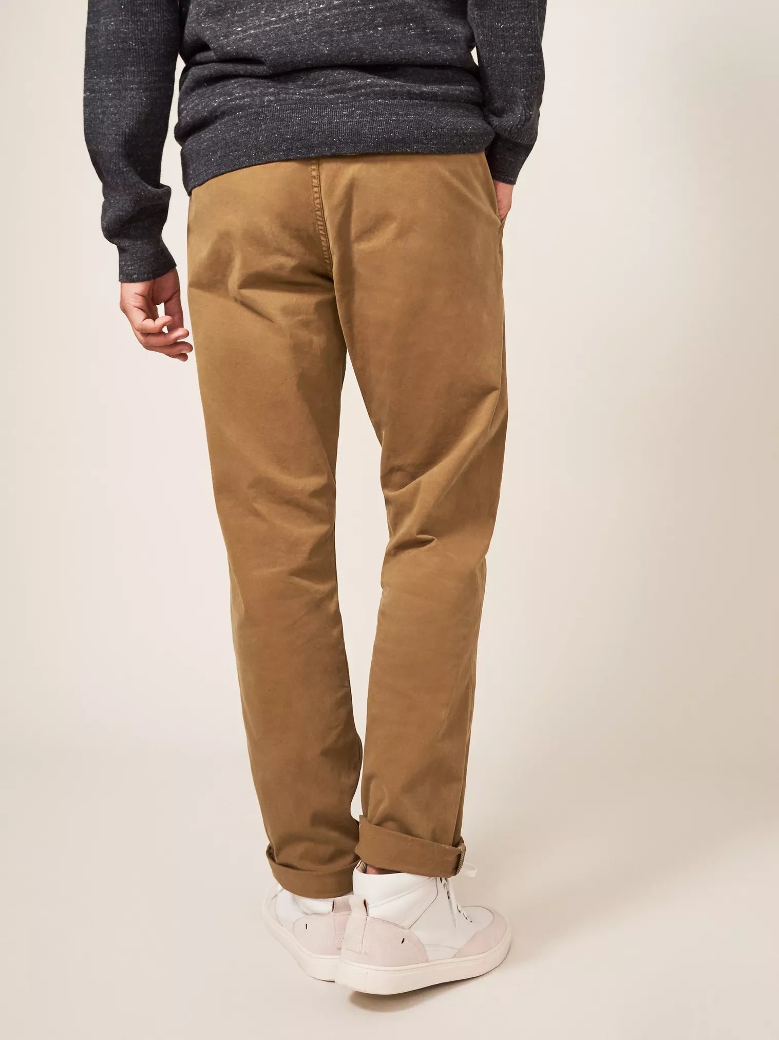 Brown straight-leg chinos, cuffed at the ankles.
