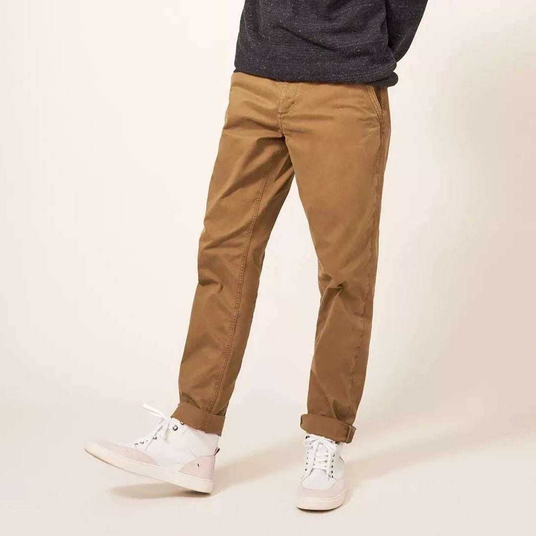 Brown chino pants, straight leg fit, cuffed at the ankles.