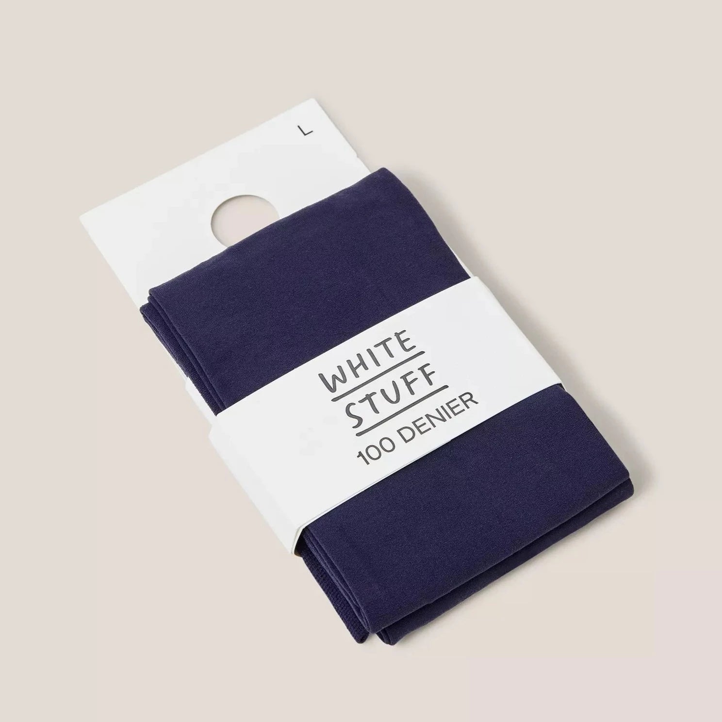 Dark blue 100 denier tights folded on white packaging labeled "WHITE STUFF".