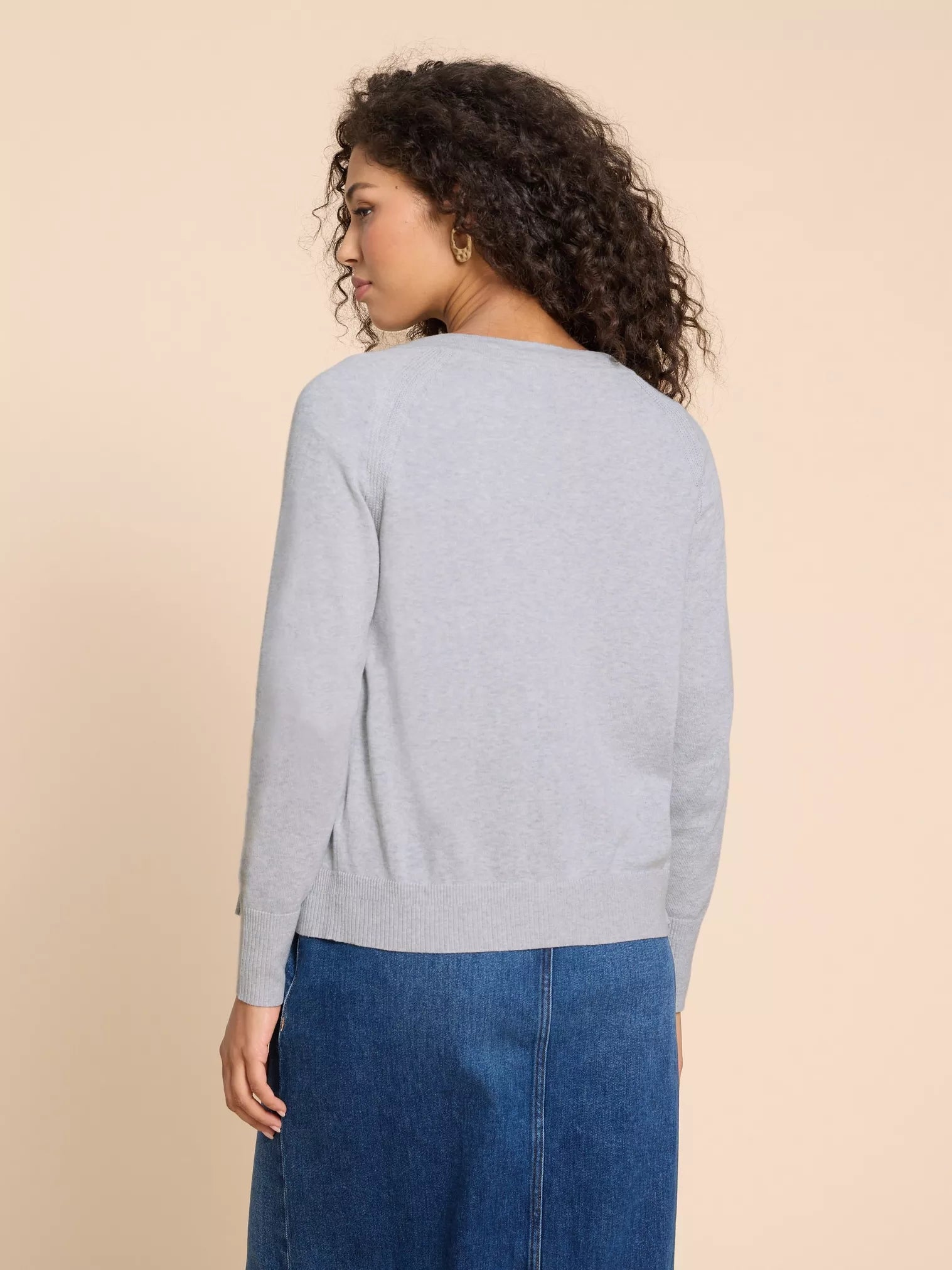 Light gray, long-sleeved, knit cardigan sweater. The sweater has a relaxed fit and a ribbed hem.