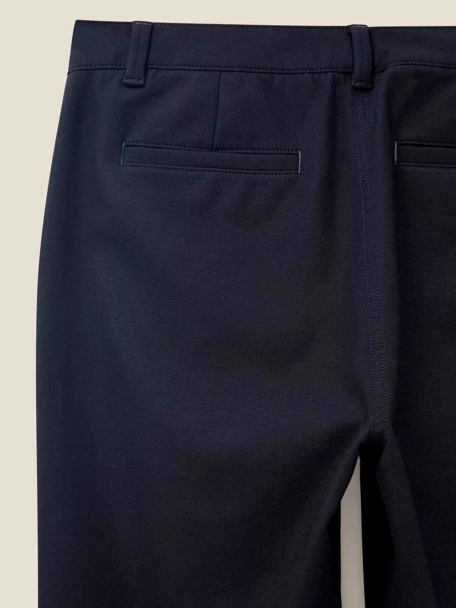 Dark navy blue women's trousers, viewed from the back, showing a waistband and back pockets.