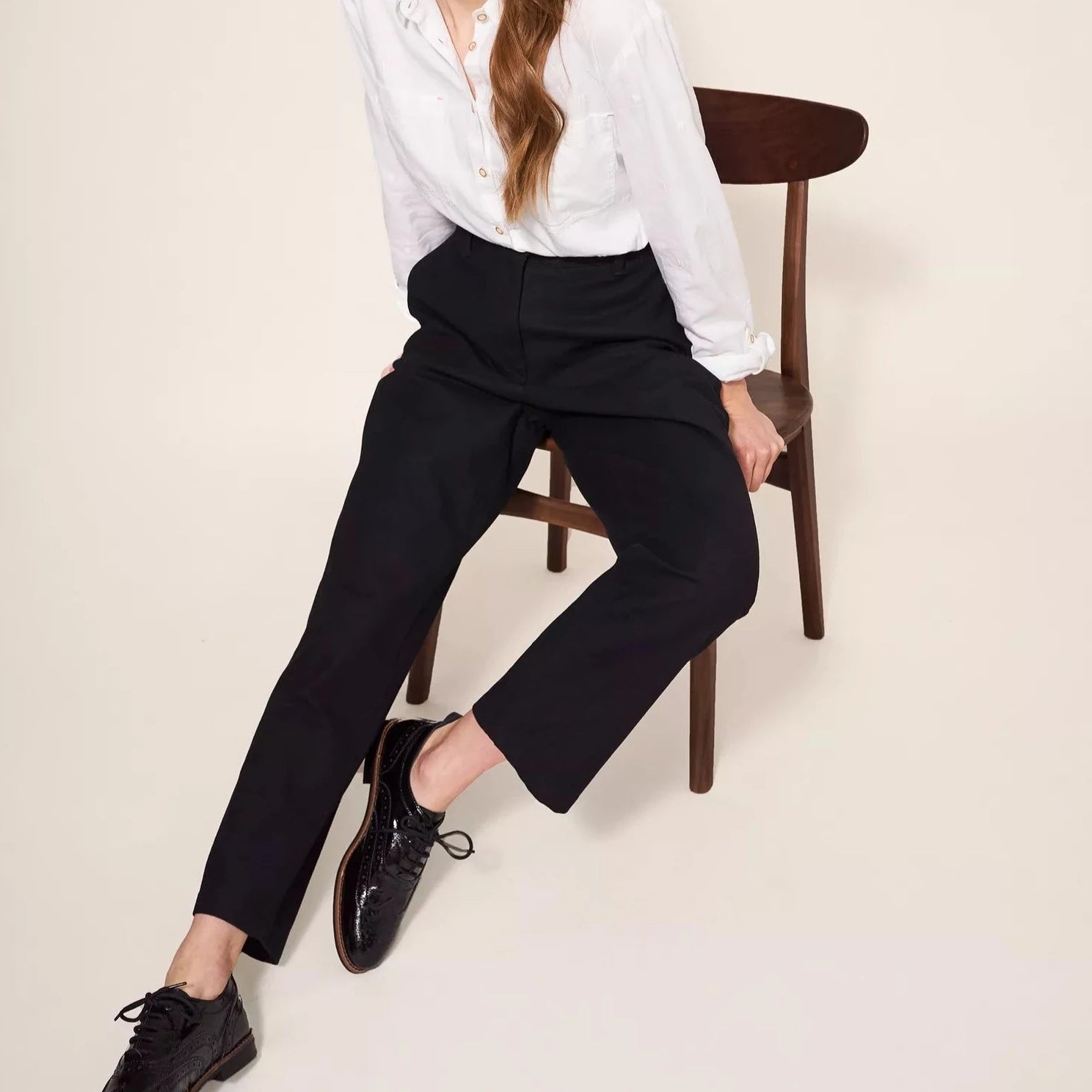 Black cropped trousers and black patent leather brogue shoes.