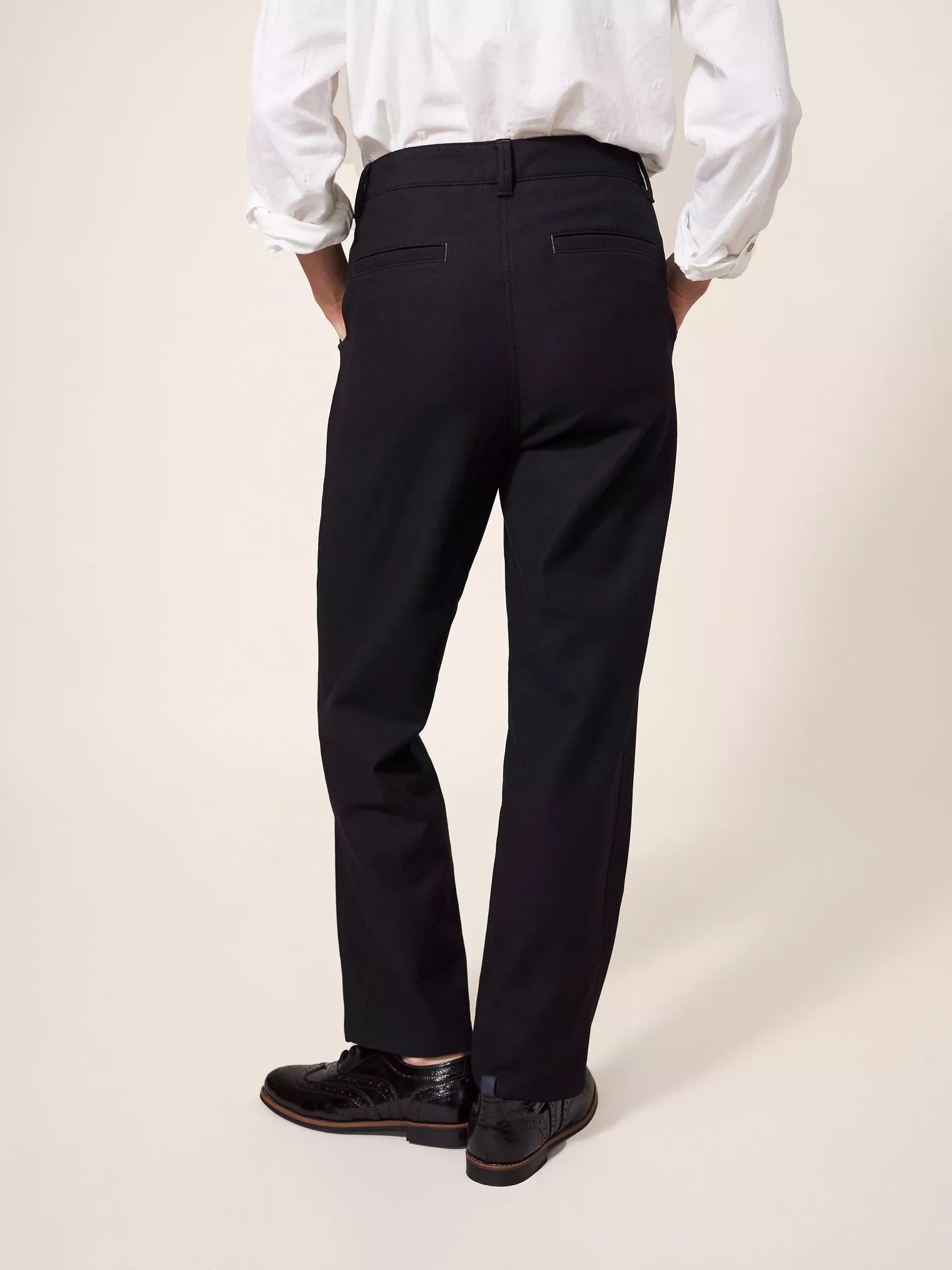 Black straight-leg trousers, viewed from the back. The pants have a mid-rise waist and a clean, tailored fit.