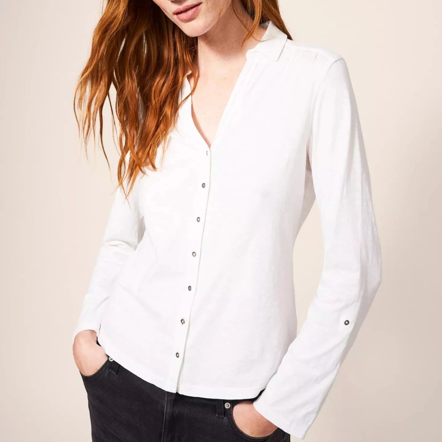 White long-sleeved collared shirt with a v-neck and button placket.