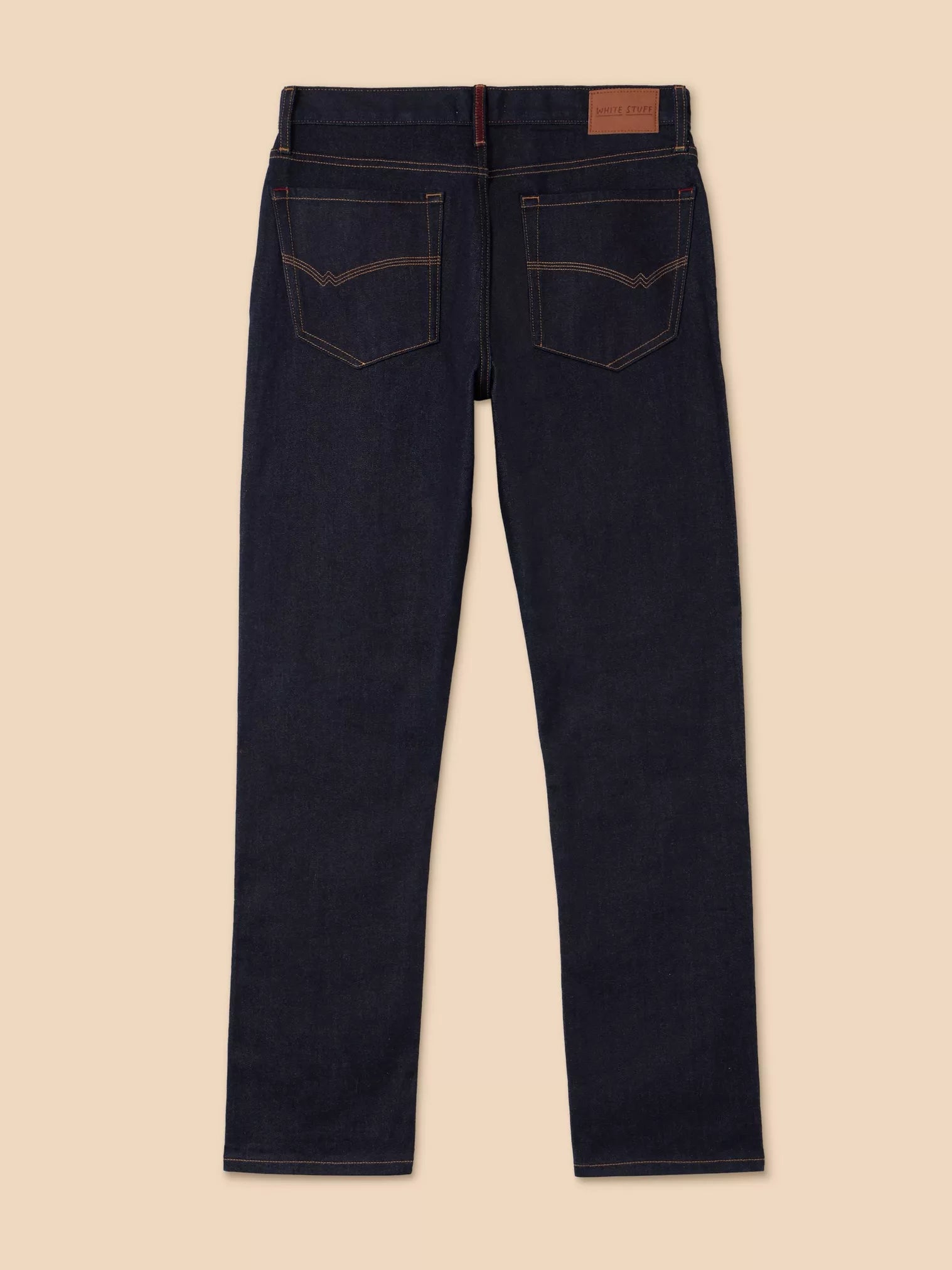 Dark blue jeans on a beige background