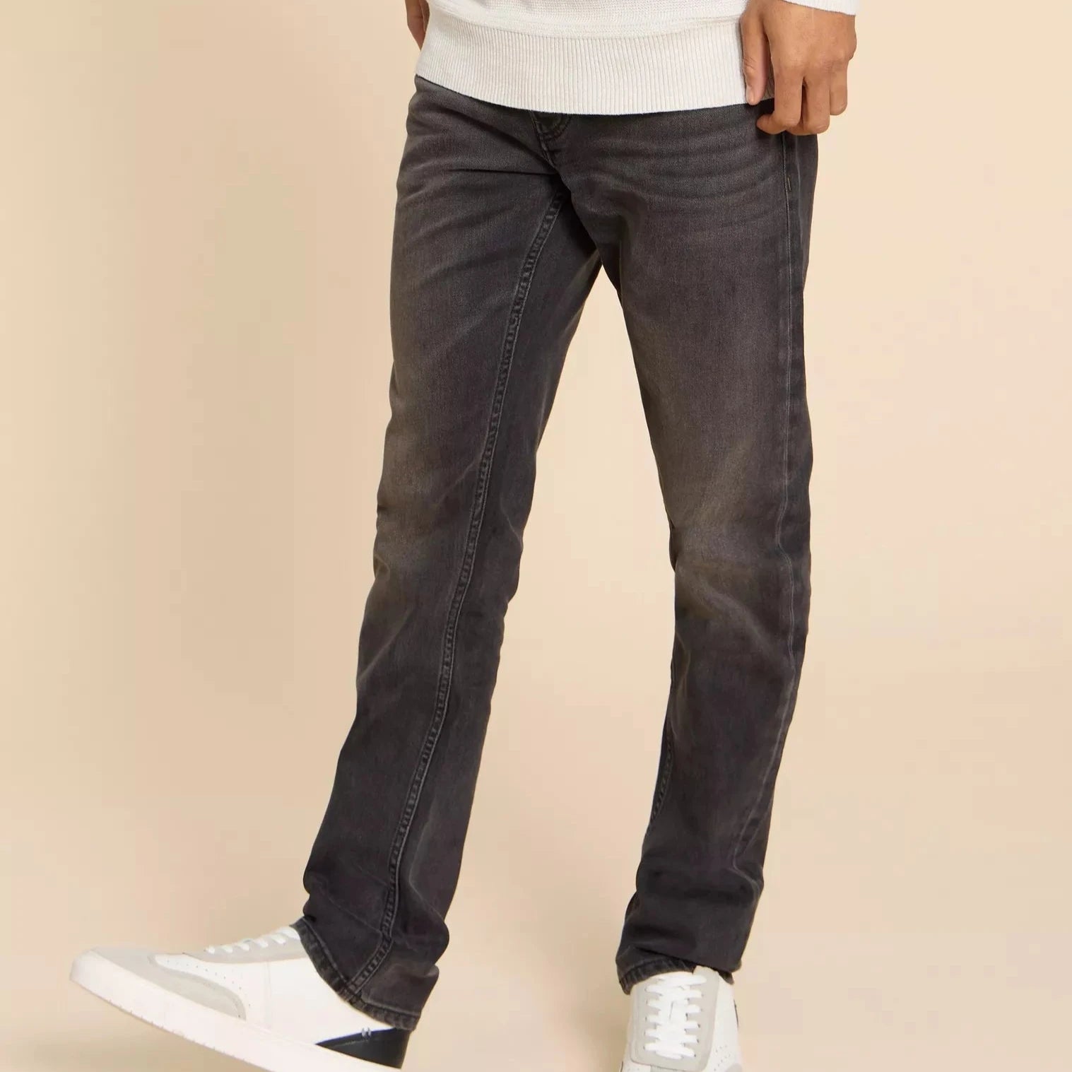 Dark gray straight-leg jeans, slightly faded, shown on a model.