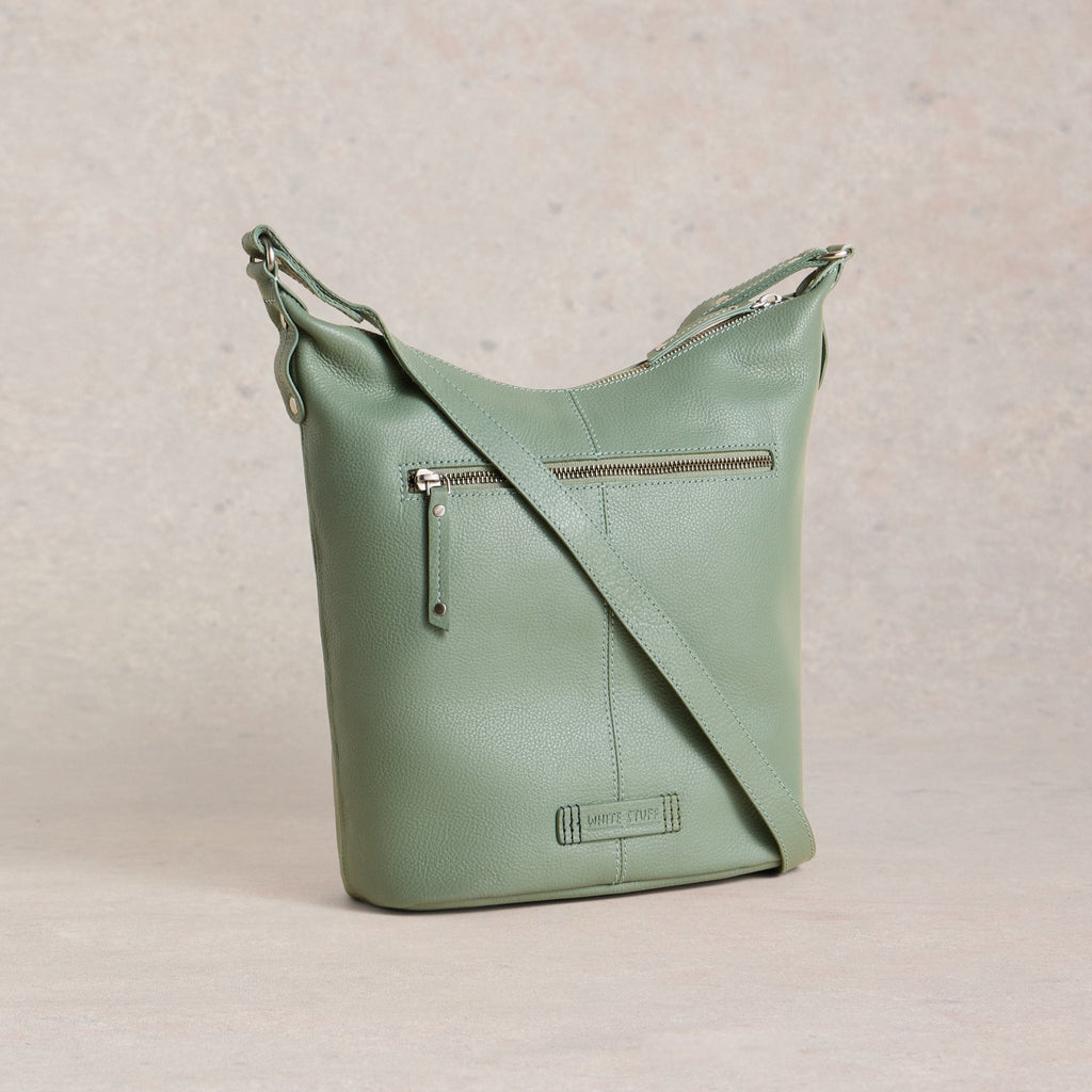 Green leather handbag on a beige background