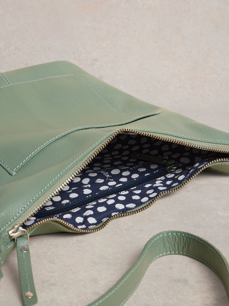 Green handbag with a polka dot interior on a neutral background