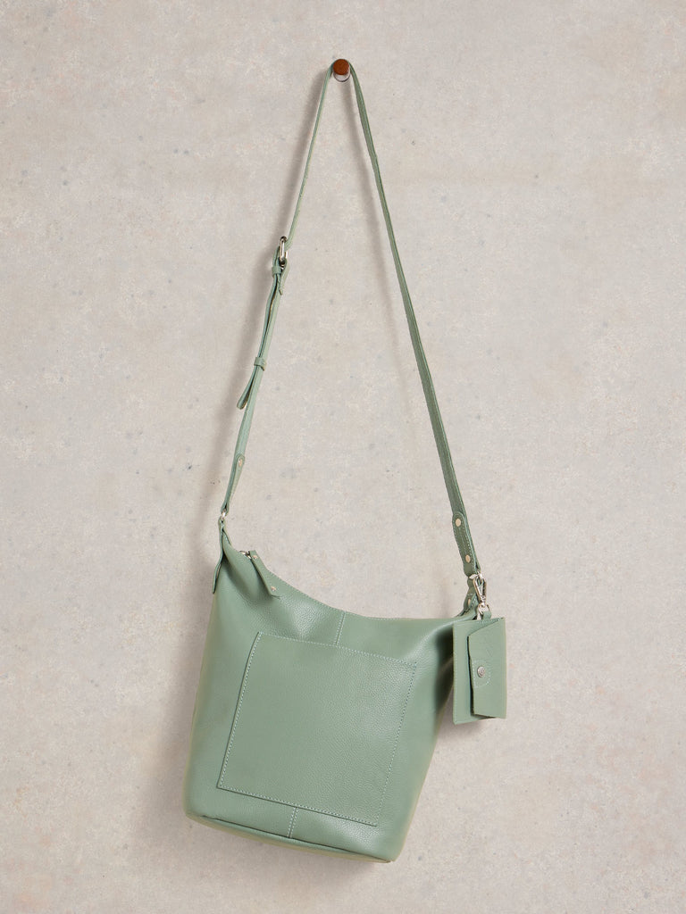Mint green handbag with a strap on a light gray background