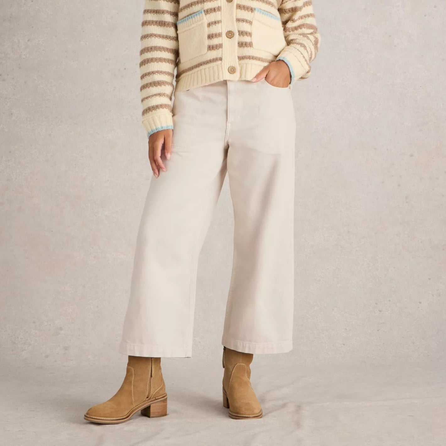 Cream-colored wide-leg cropped jeans; a model wears them with tan suede ankle boots.