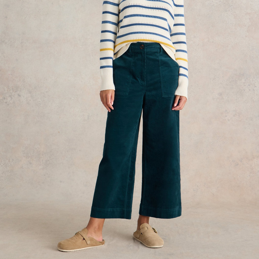 Dark teal corduroy wide-leg pants with front pockets, shown on a model.