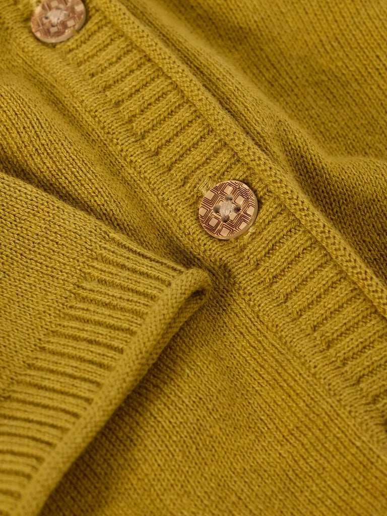 Close-up of a mustard yellow knit cardigan with detailed wooden buttons.