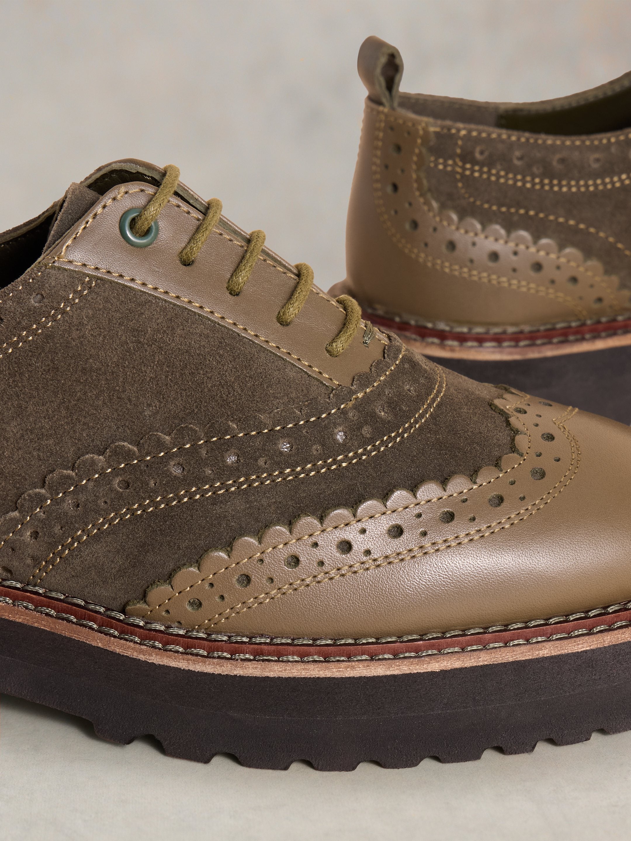 Olive green leather and suede brogue shoes with scalloped detailing and a chunky platform sole. Lace-up closure.