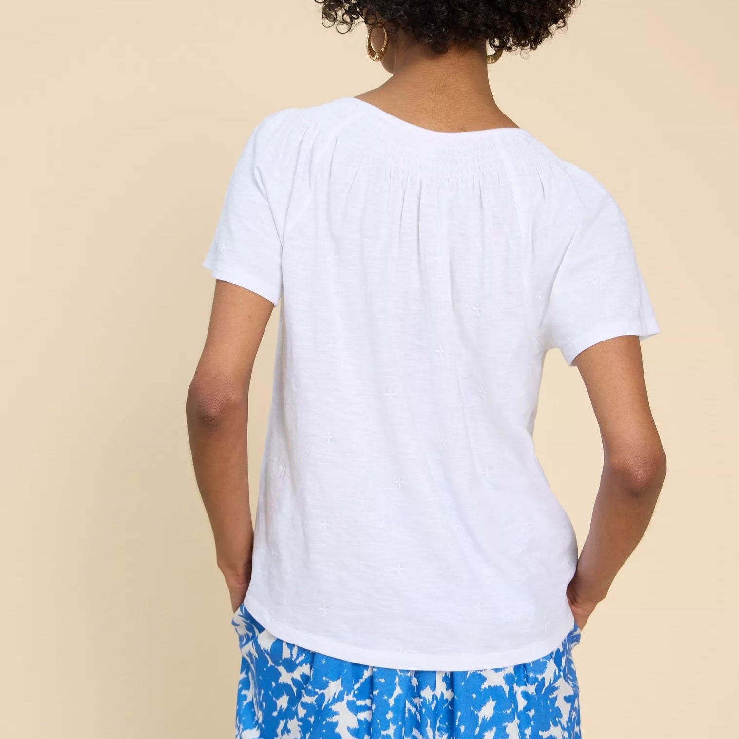 White embroidered cotton t-shirt with short sleeves and a slightly gathered neckline.