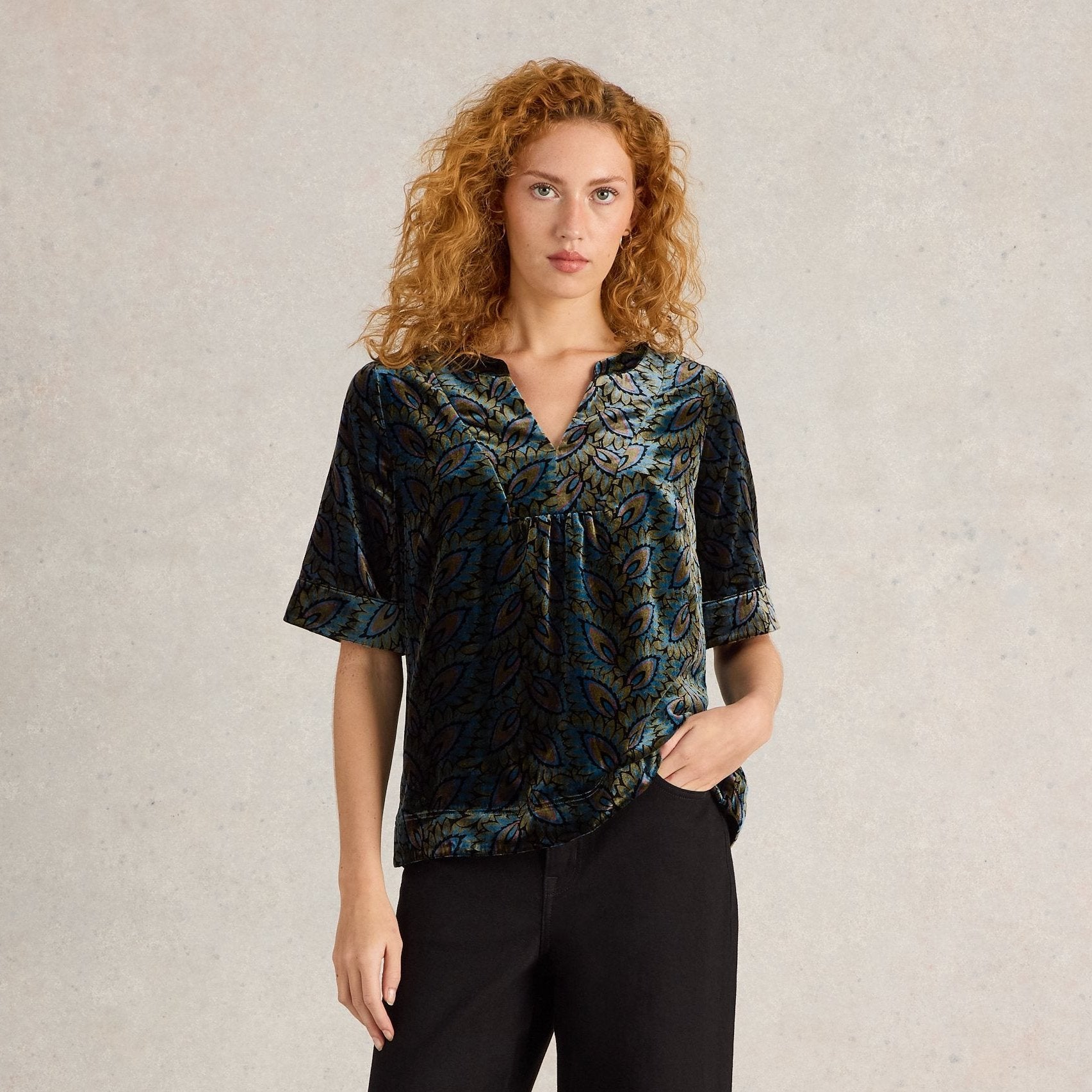 Teal velvet short-sleeved top with a V-neck and an all-over leaf print.