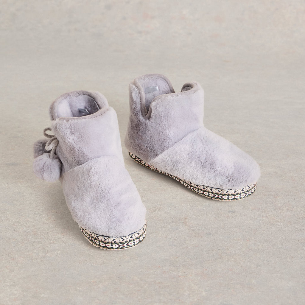 Pair of gray faux fur slipper boots with pom-pom detail and patterned trim.