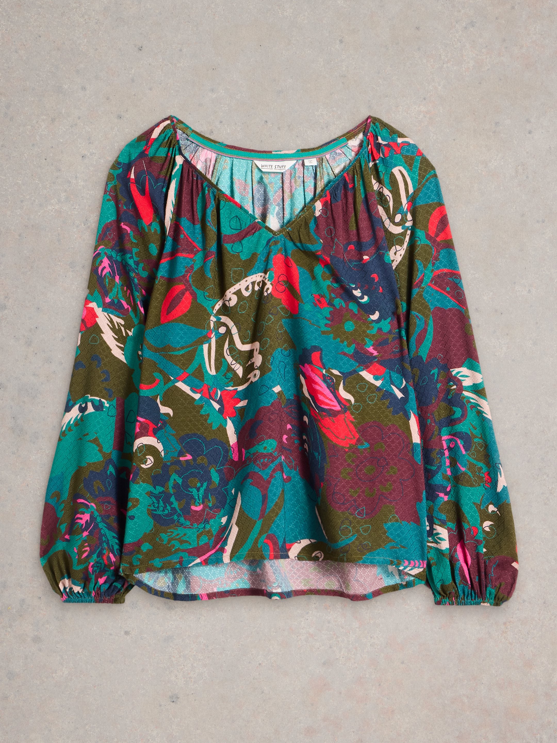 Women's long-sleeve blouse with a V-neck and an abstract floral print in teal, olive, maroon, and pink.