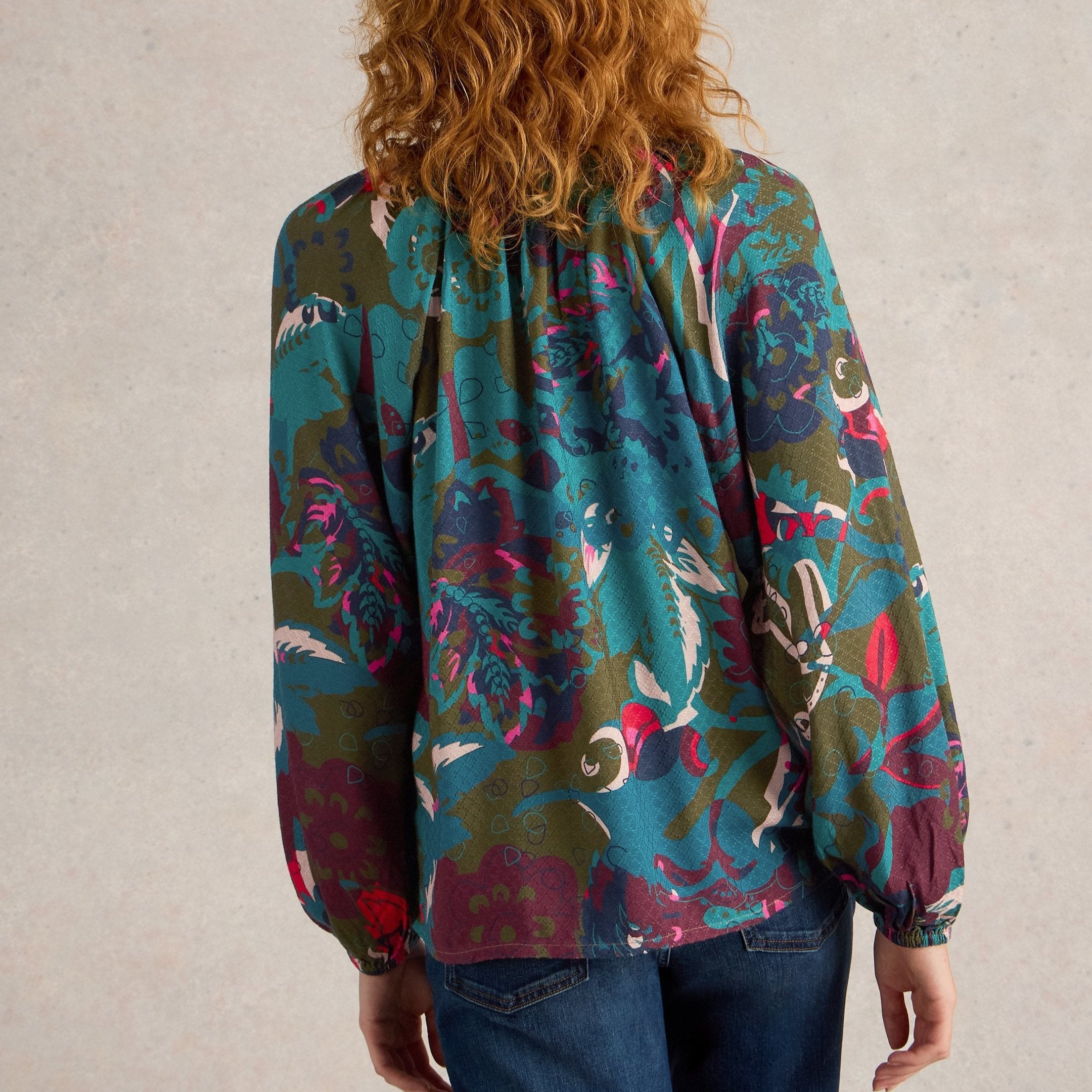 Women's long-sleeve blouse with a teal, olive, and burgundy abstract floral print.