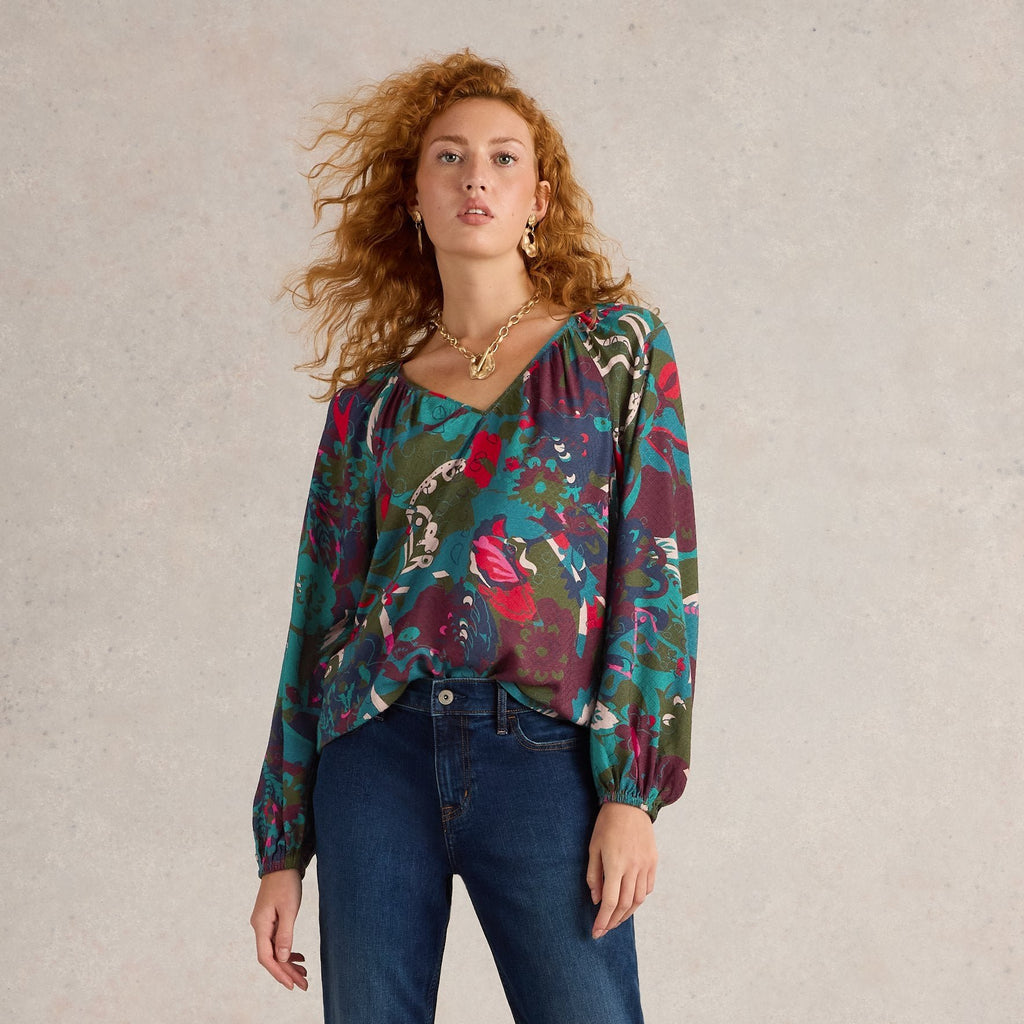 Abstract floral print blouse with long sleeves and a V-neck. Teal, pink, and burgundy colors on a dark background.