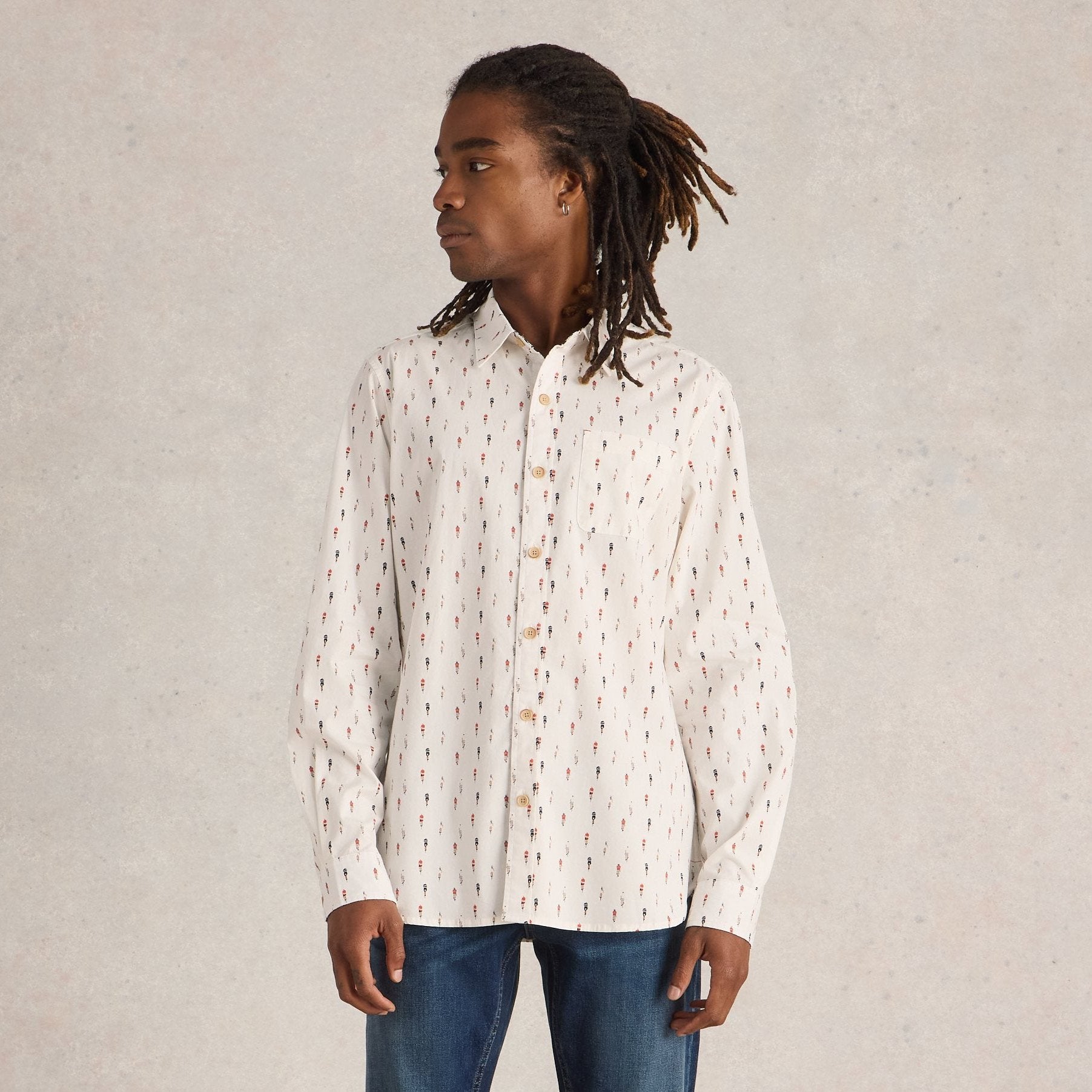 Off-white long-sleeve button-down shirt with a repeating small, stylized floral print in black and red.