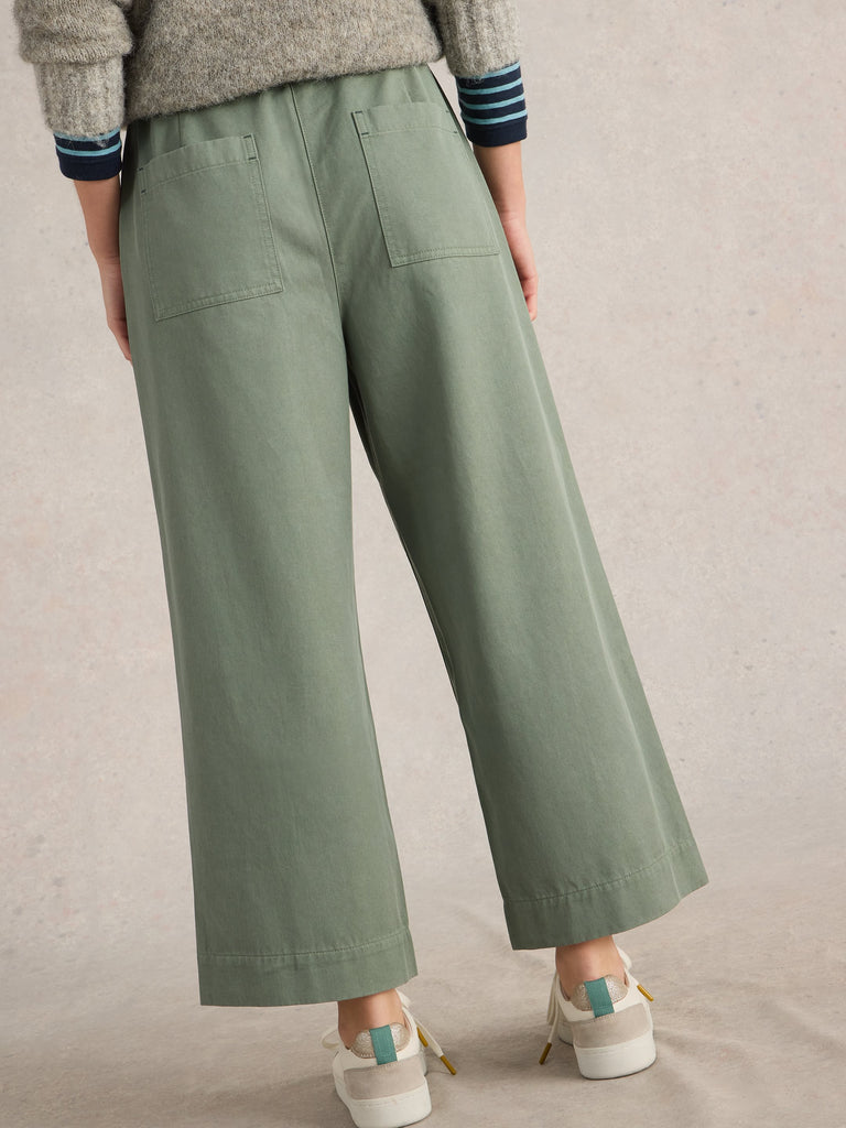 Sage green wide-leg cropped pants with back pockets and a drawstring waist.
