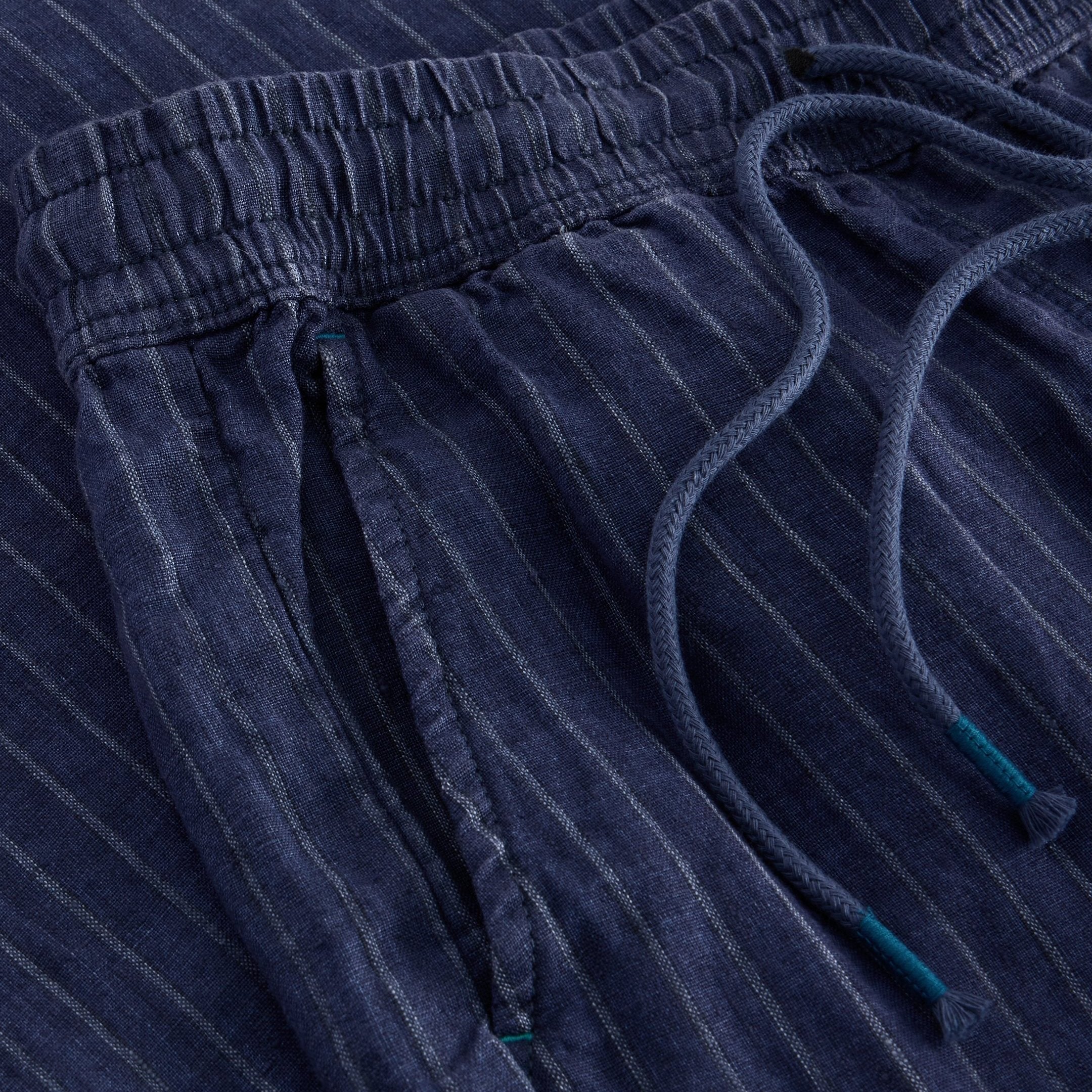 Close-up of navy blue pinstripe linen pants with drawstring waist.