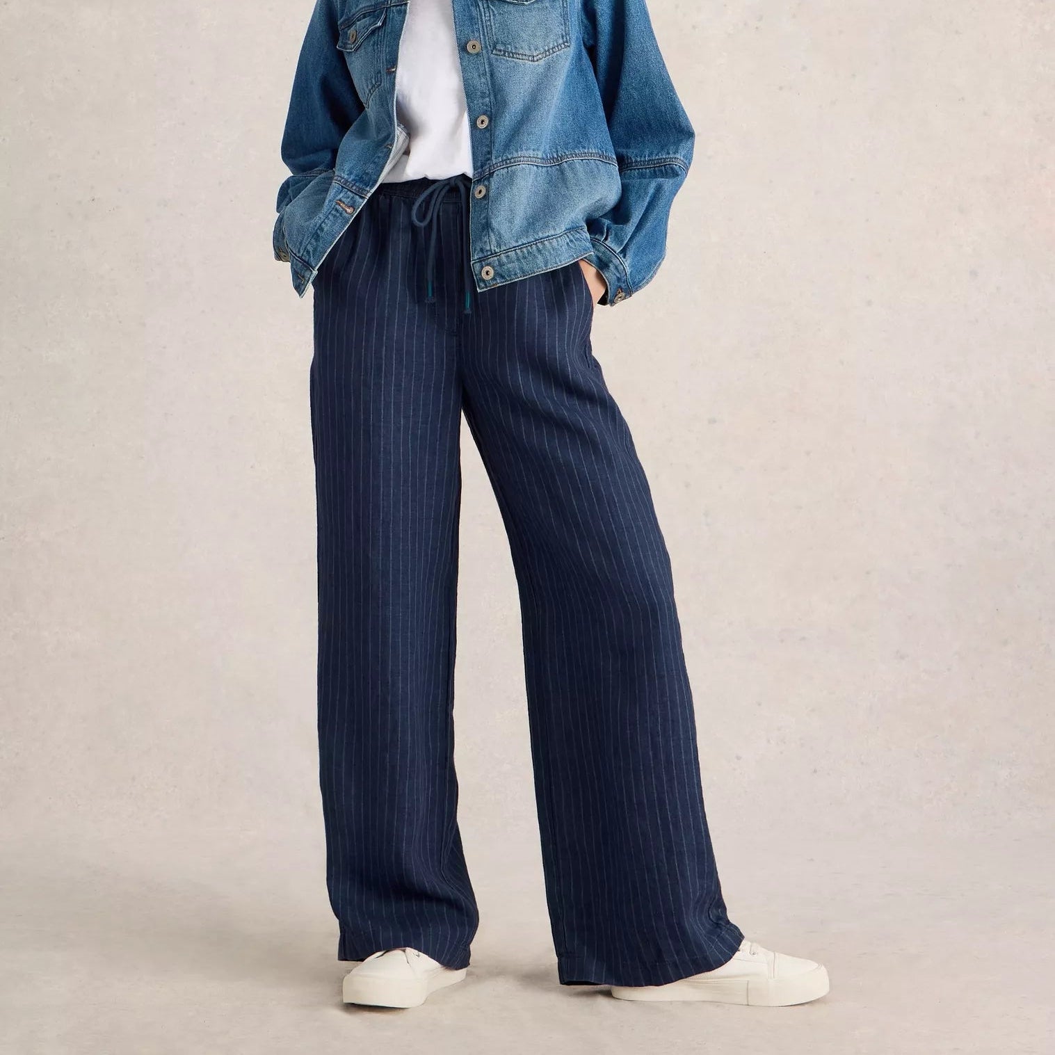 Navy blue pinstripe wide-leg linen pants with drawstring waist.